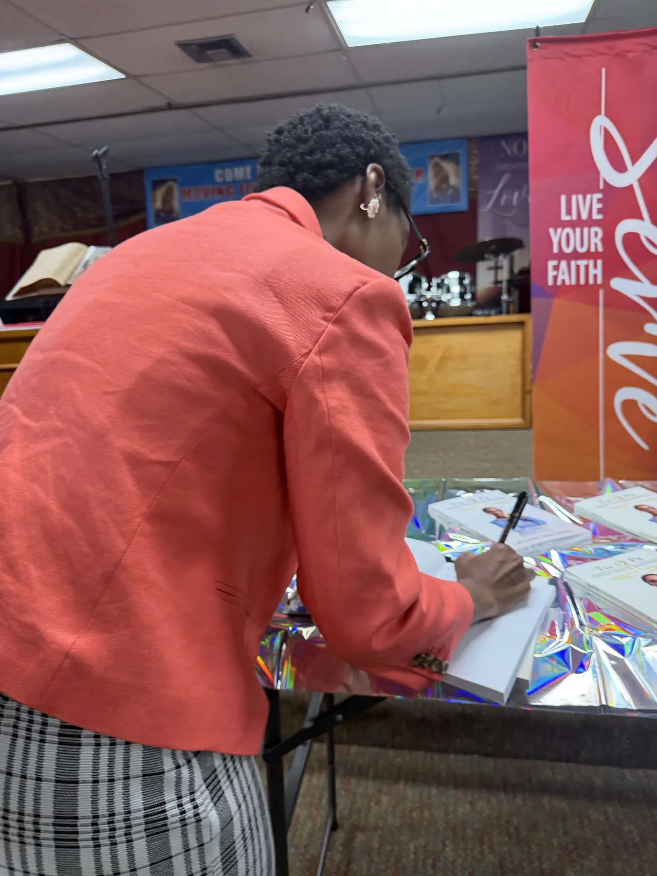 Rolanda signing materials during the conference